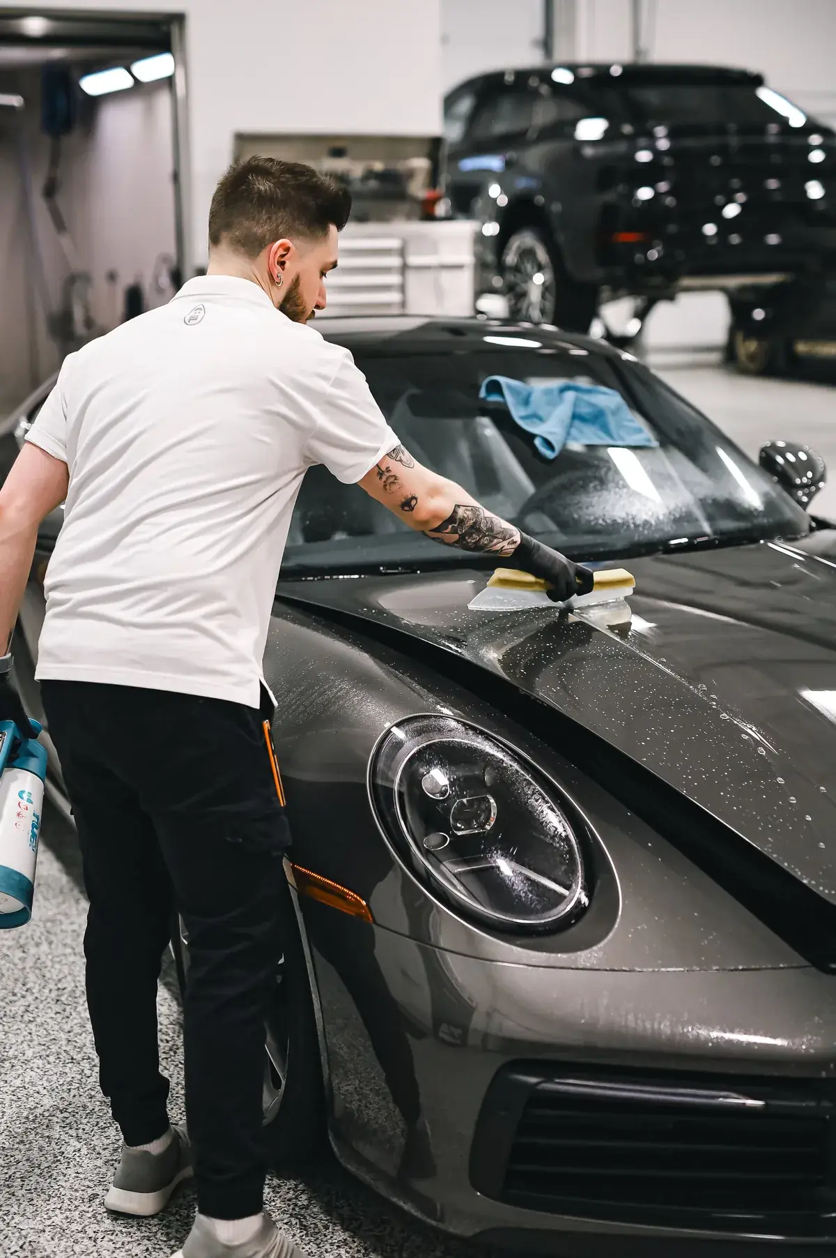 Installer applying paint protection film to a bonnet